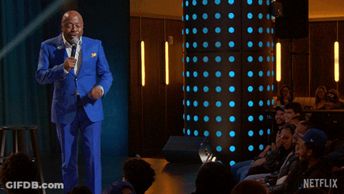 A Man In A Blue Suit Stands In Front Of A Crowd With The Words " Everybody Gets A Therapist " GIF