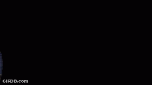 A Man In A Blue Suit Stands In Front Of A Mpire Estates Logo GIF