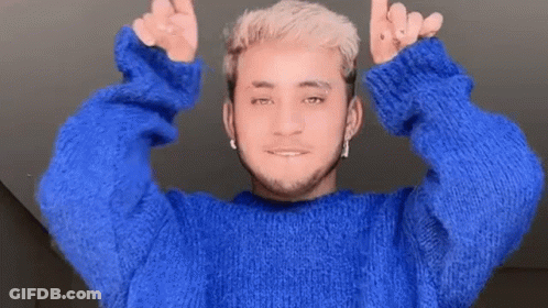 A Man In A Blue Sweater Is Giving A Thumbs Up Sign GIF