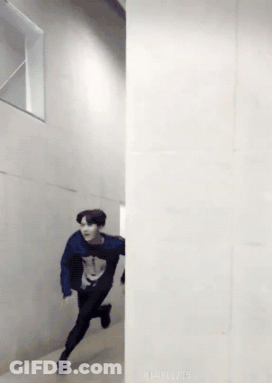 A Man In A Blue Sweater Is Running Between Two Walls GIF