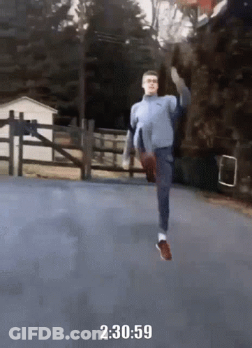 A Man In A Blue Sweater Is Running On A Road With The Time Of 2 : 30 : 59 GIF
