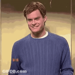 Man In Blue Sweater Smiling In Front Of Wall GIF
