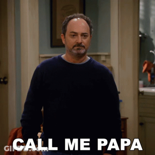 A Man In A Blue Sweater Is Standing In A Hallway And Says Call Me Papa GIF