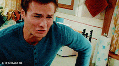 A Man In A Blue Sweater Is Standing In A Kitchen GIF