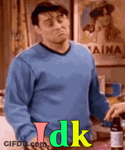A Man In A Blue Sweater Is Standing In Front Of A Sign That Says " Aina " GIF