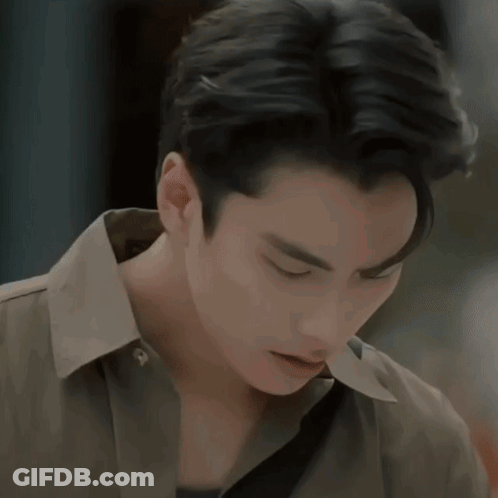 A Man In A Blue Sweater Looks At Another Man In A Brown Jacket GIF