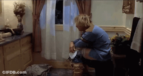 A Man In A Blue Sweater Sits On A Toilet GIF
