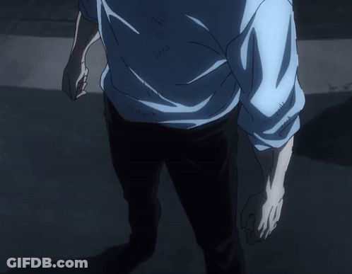 A Man In A Blue Sweater Stands In The Dark GIF