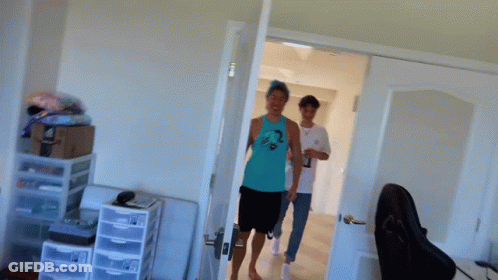 A Man In A Blue Tank Top Is Standing In A Room With The Words Why Do You Look GIF