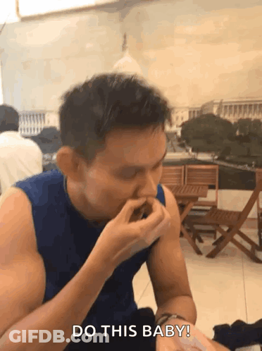 A Man In A Blue Tank Top Says " Do This Baby " While Eating GIF