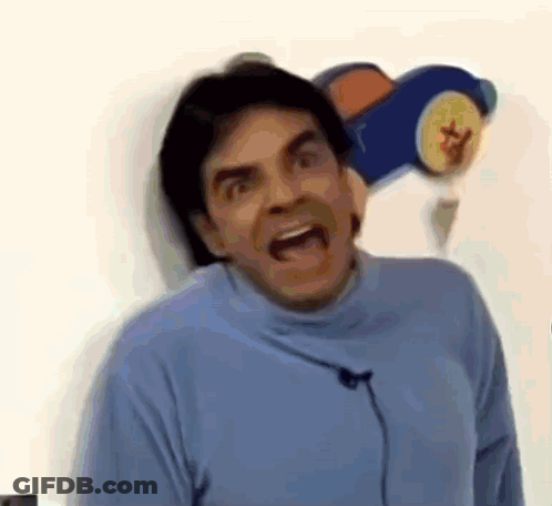 A Man In A Blue Turtleneck Sweater Is Making A Funny Face . GIF