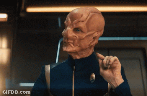 A Man In A Blue Uniform Has A Star Trek Logo On His Jacket GIF