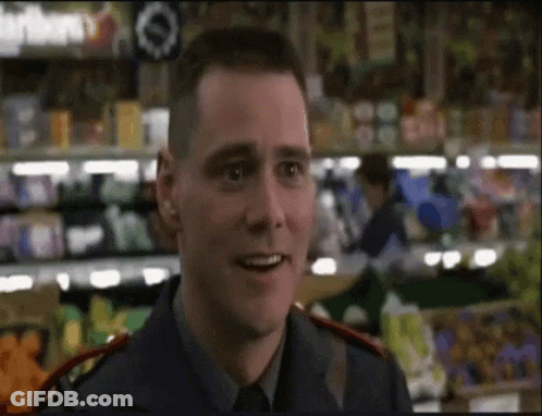 A Man In A Blue Uniform Is Smiling In Front Of A Grocery Store GIF