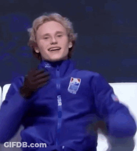 A Man In A Blue Usa Jacket Covering His Mouth With His Hand GIF