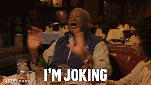 A Man In A Blue Vest Says I 'M Joking In A Restaurant GIF