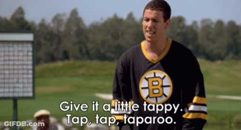 A Man In A Boston Bruins Jersey Is Standing On A Golf Course And Talking To Another Man . GIF