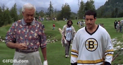 A Man In A Boston Bruins Jersey Is Standing On A Golf Course Next To A Man In A Floral Shirt . GIF