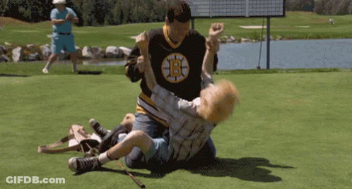 A Man In A Boston Bruins Jersey Is Wrestling Another Man In A Golf Course . GIF