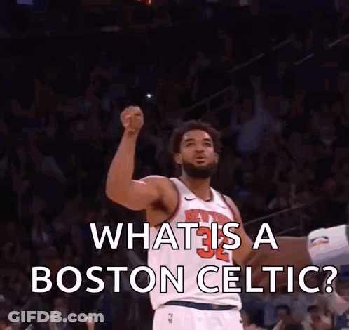 A Man In A Boston Celtic Jersey Holds His Fist Up In The Air GIF