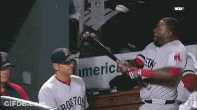 A Man In A Boston Jersey Is Swinging A Bat At Another Man GIF