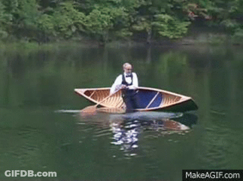 A Man In A Bow Tie Is Rowing A Boat On A Lake GIF