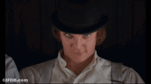 A Man In A Bowler Hat Drinks Milk From A Glass GIF