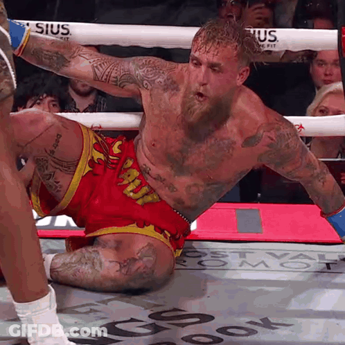 A Man In A Boxing Ring Is Wearing Shorts That Say Snoopy GIF