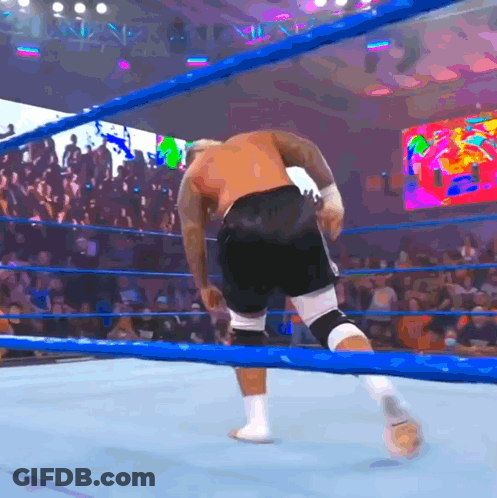 A Man In A Boxing Ring With A Crowd Behind Him GIF