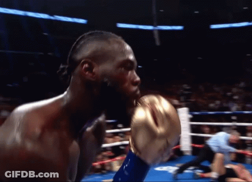 A Man In A Boxing Ring With A Referee Behind Him GIF