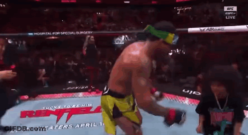 A Man In A Boxing Ring With A Sign That Says ' Rent ' On It GIF