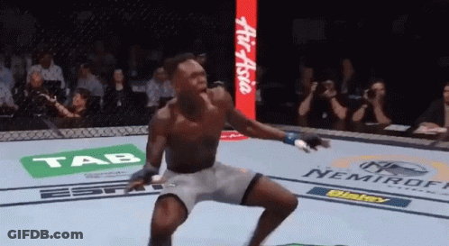 A Man In A Boxing Ring With Ads For Tab And Nemiroff In The Background GIF