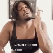 A Man In A Bra Is Smoking A Cigarette While Wearing A Wig . GIF