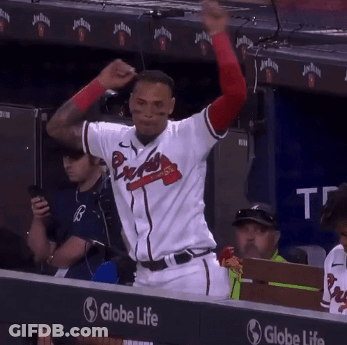 A Man In A Braves Jersey Stands In Front Of A Globe Life Sign GIF
