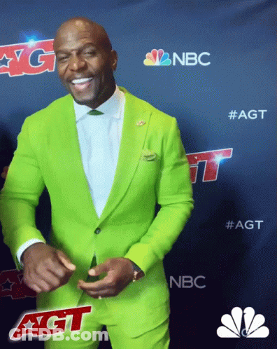 A Man In A Bright Green Suit Is Smiling In Front Of A Nbc Logo GIF