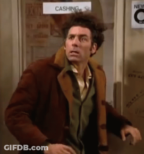 A Man In A Brown Coat Is Standing In Front Of A Door With A Sign On It That Says Cashing . GIF