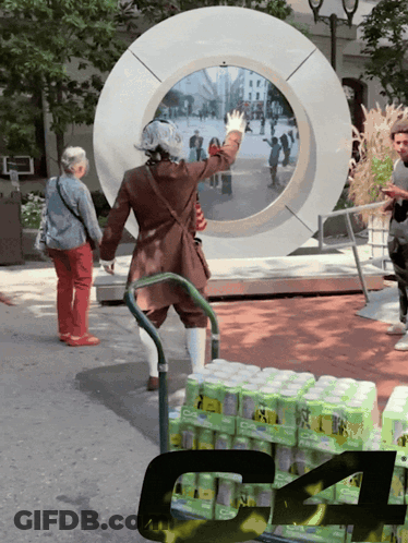 A Man In A Brown Coat Is Standing In Front Of A Large Circle With A Bunch Of Cans Of Soda GIF