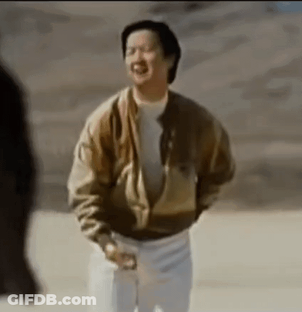 A Man In A Brown Jacket And White Pants Is Standing In A Desert . GIF