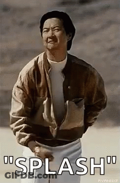 A Man In A Brown Jacket And White Shorts Is Standing In The Dirt And Talking . GIF