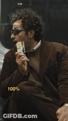 A Man In A Brown Jacket Is Eating A Cheerios Bar GIF