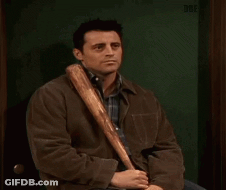 A Man In A Brown Jacket Is Holding A Baseball Bat In His Hand . GIF
