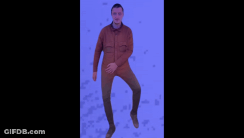 A Man In A Brown Jacket Is Jumping In The Air With His Arms Outstretched GIF