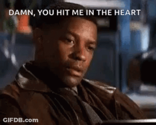 A Man In A Brown Jacket Is Sitting At A Table And Says `` Damn You Hit Me In The Heart '' . GIF
