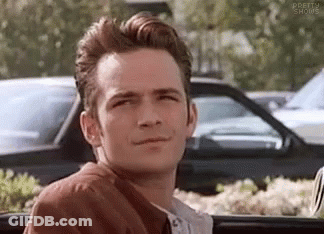 A Man In A Brown Jacket Is Sitting In The Back Seat Of A Car . GIF