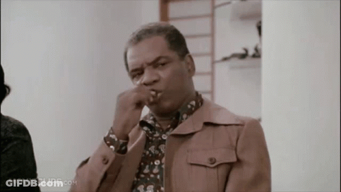 A Man In A Brown Jacket Is Smoking A Cigarette In A Movie Clip GIF