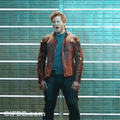 A Man In A Brown Leather Jacket Is Standing In Front Of A Brick Wall With His Mouth Open . GIF