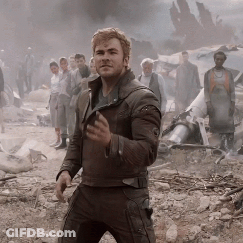 A Man In A Brown Leather Jacket Stands In Front Of A Crowd GIF