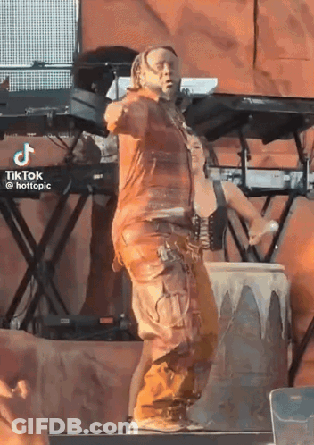 A Man In A Brown Outfit Is Dancing On A Stage With A Tiktok Watermark GIF