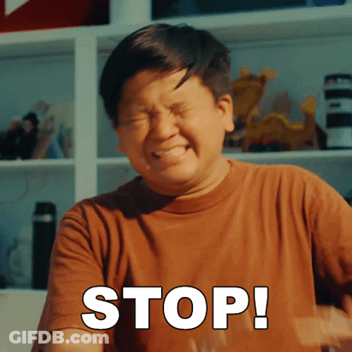 A Man In A Brown Shirt Is Making A Stop Sign With His Eyes Closed GIF
