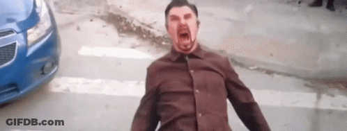 A Man In A Brown Shirt Is Screaming In Front Of A Blue Car On A City Street . GIF
