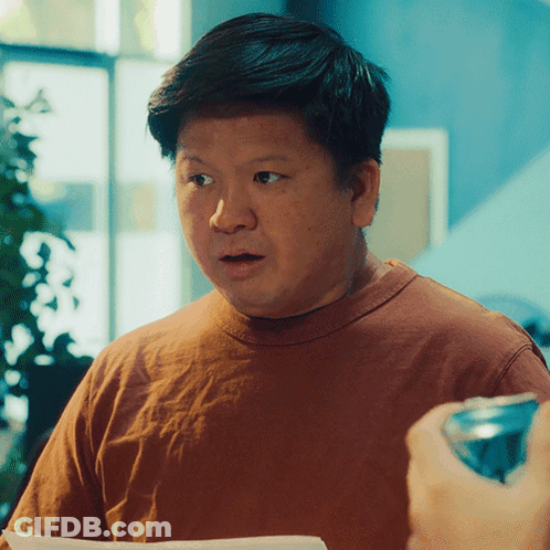 A Man In A Brown Shirt Looks Surprised While Holding A Can Of Soda GIF